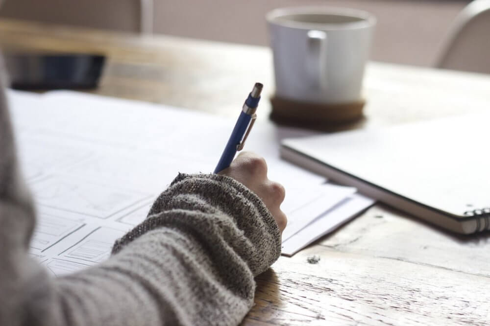 Student writing on a desk