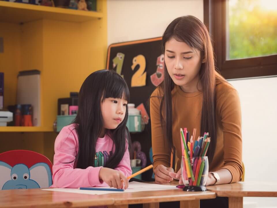 Tutor teaching a young girl