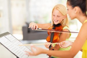 Tutor teaching violin