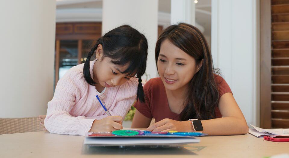 Tutor teaches girl to draw on the book