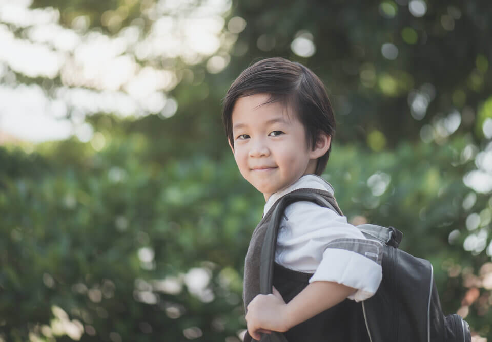 Portrait of Asian student with backpack outdoors