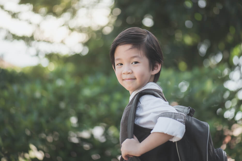 Portrait of Asian student with backpack outdoors