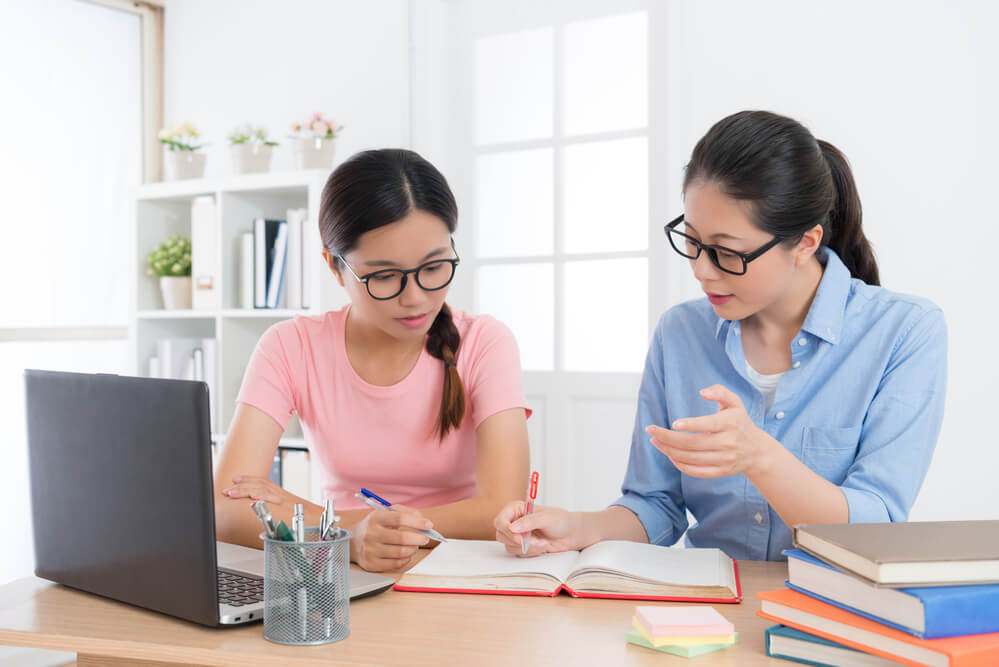 home tutor woman teaching young female student